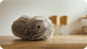 An image of a silver-colored Moflin placed on a dressing table.