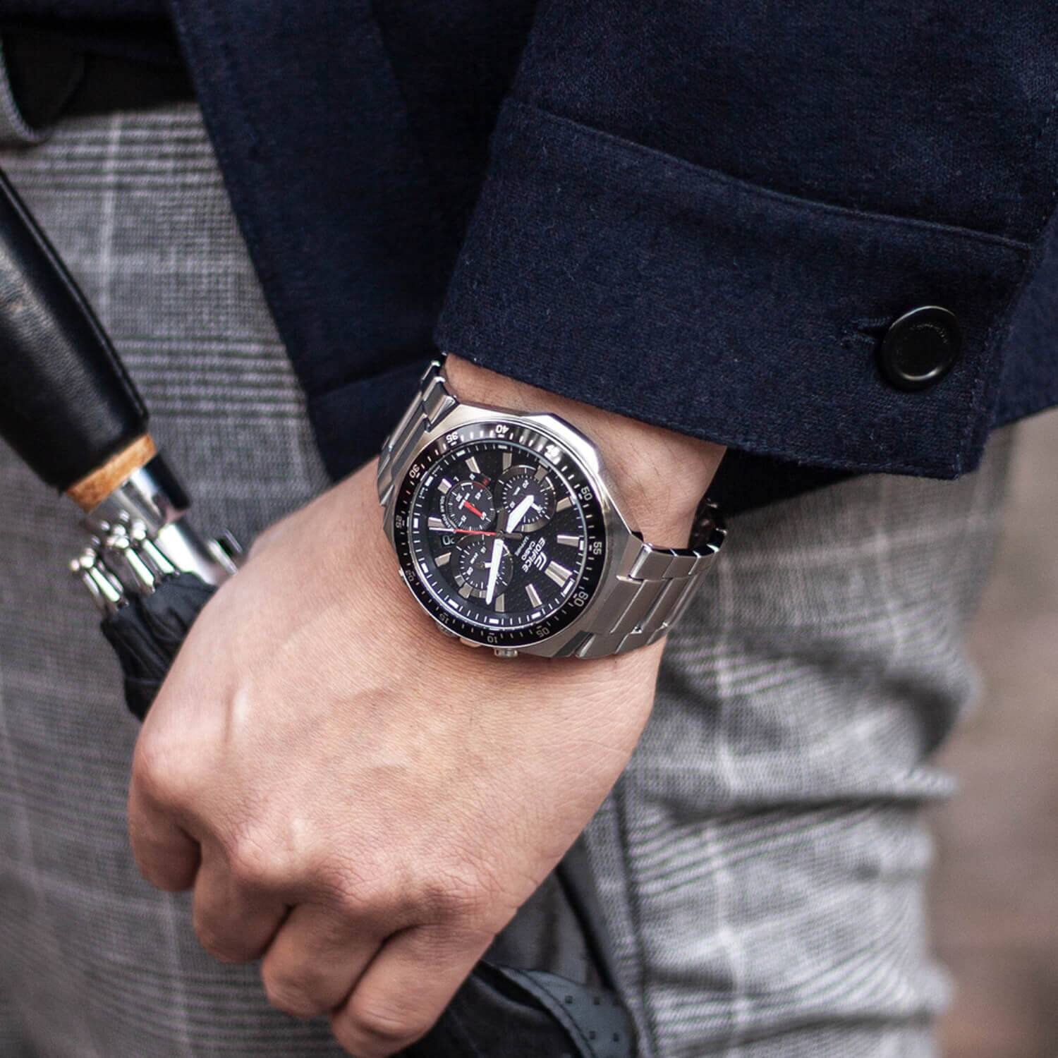 A man carries the EFS-S600D-1A4 and holds an umbrella. In the bleed, you can see his gray plaid pants.