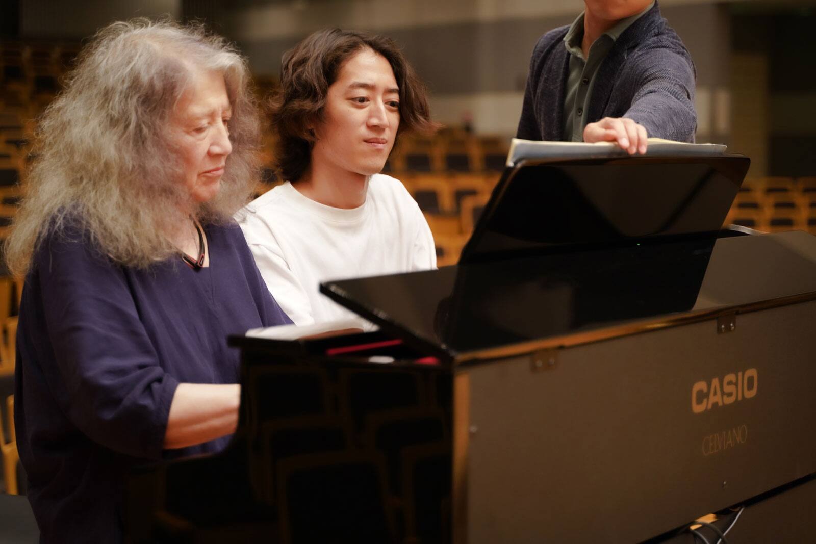 Martha Argerich and Hayato Sumino sitting in front of the piano
