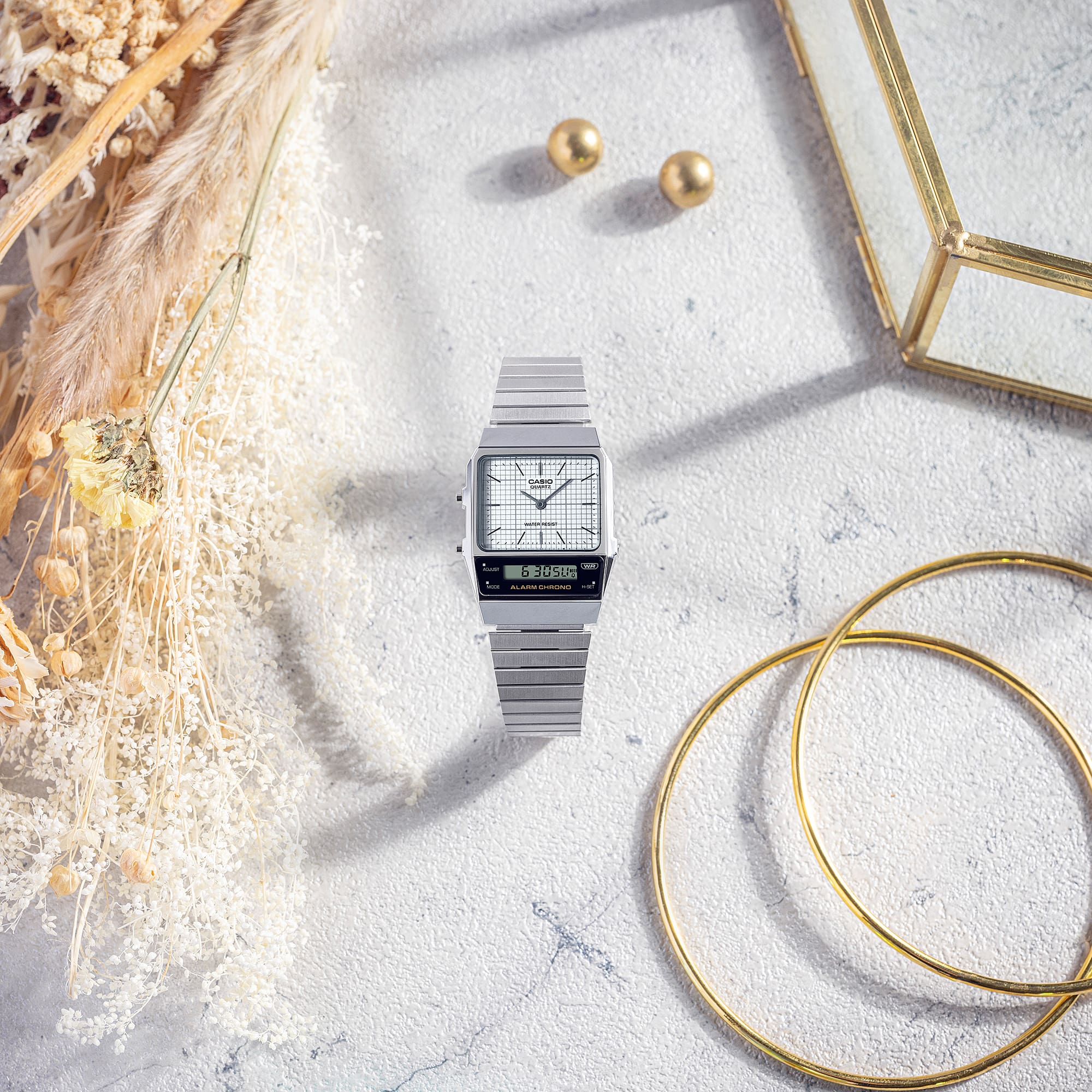 Casio AQ800E-7A watch amidst earrings and bracelets, denoting style