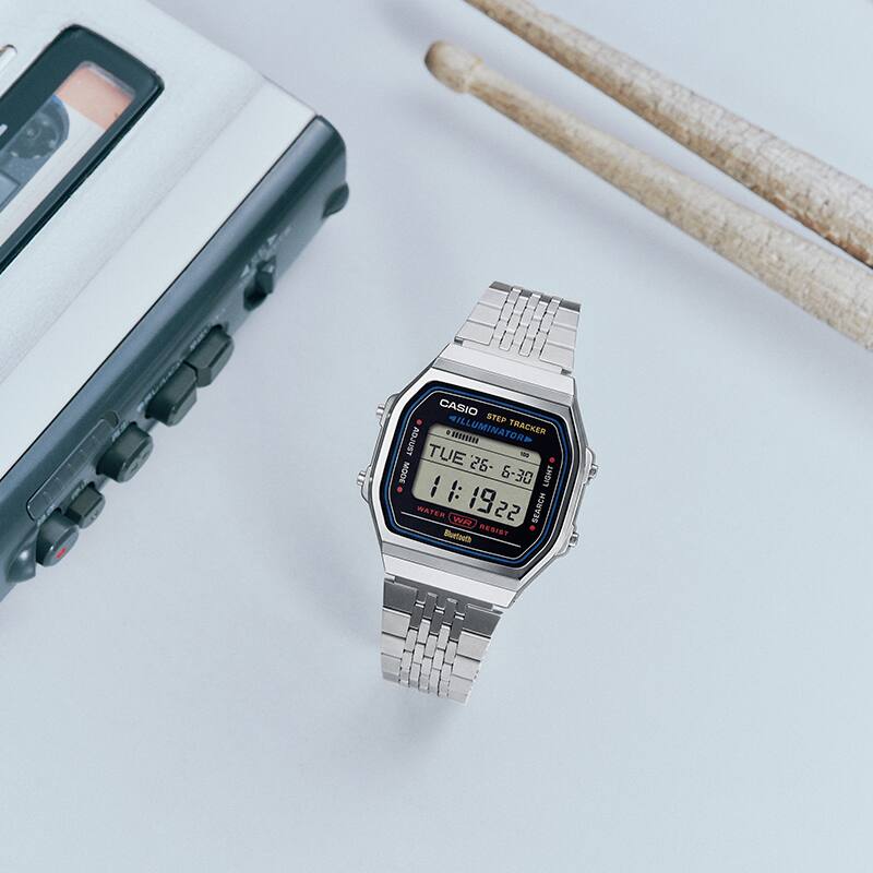 This is a photo of the G-SHOCK ABL-100WE-1A placed with drumsticks and audio equipment.
