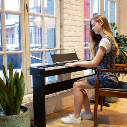 Frau spielt auf dem CASIO CDP-S100 Compact Digital Piano in Schwarz - Lifestyle-Aufnahme. 