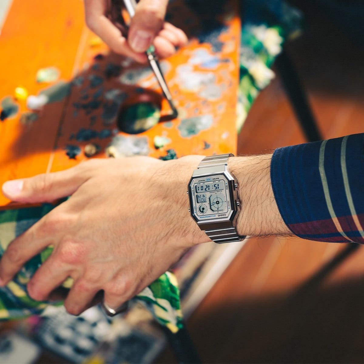 Nahaufnahme auf das Handgelenk eines Mannes, der die digitale Armbanduhr A130WE am Handgelenk trägt und eine Farbpalette nutzt.