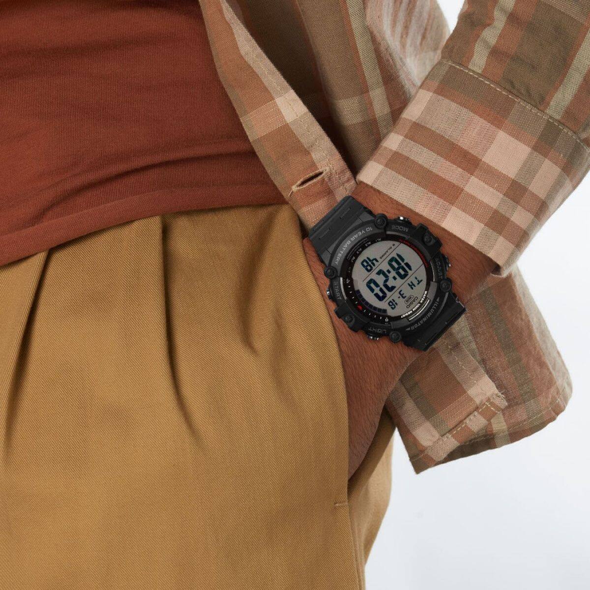 Die AE-1500WH-1AV am Handgelenk eines Mannes, welcher ein kariertes Hemd, ein rostrotes T-Shirt und eine senfgelbe Hose trägt