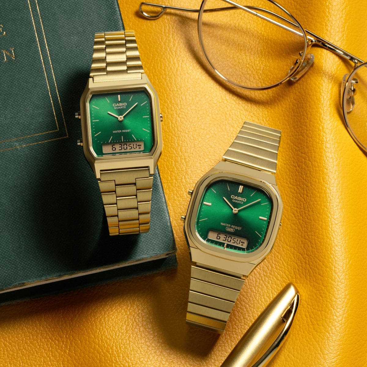 Die beiden Modelle AQ-230GA-3AMQY und AQ-240EG-3A, jeweils in Gold mit grünem Zifferblatt, liegen nebeneinander