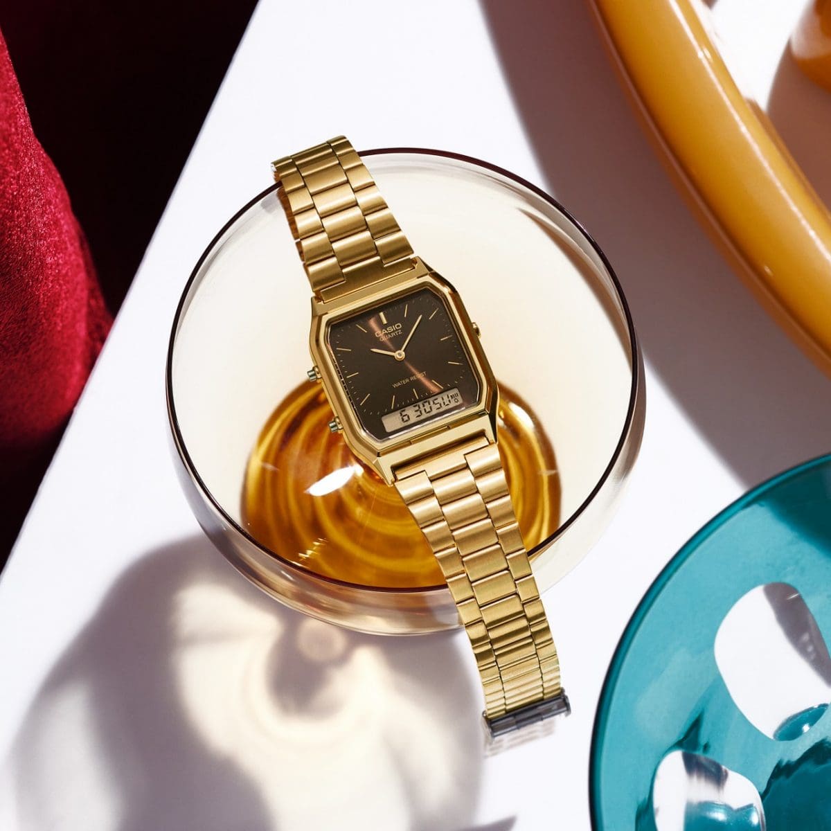 Die goldene Armbanduhr AQ-230GA-5AMYES liegt auf dem Rand eines Kaffeeglases
