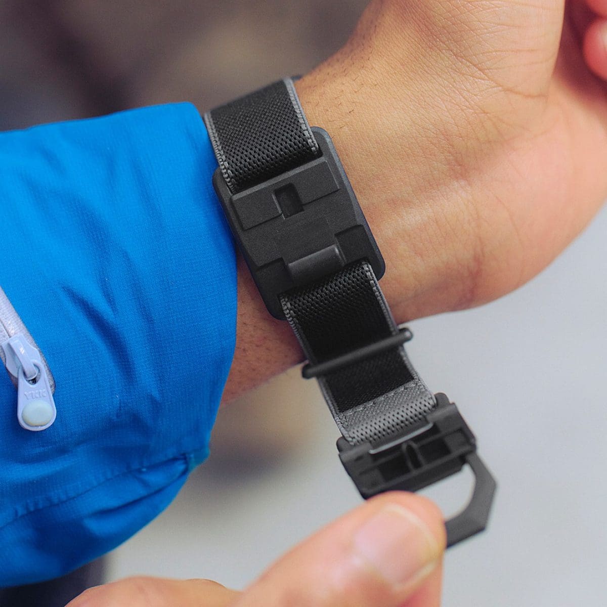 Ein Mann trägt die Digitaluhr DW-5600MNC-1ER am Handgelenk und öffnet die FIDLOCK®-Magnetschließe mit einer Hand