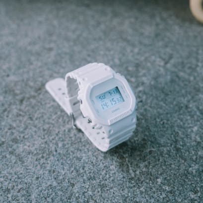 Die DW-5600WW-7 steht mit geschlossenem Armband auf einem Steinboden und ist leicht schräg von der linken Seite zu sehen