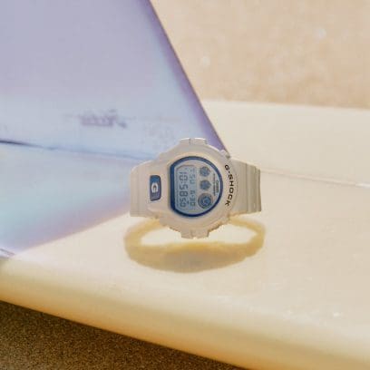 DW-6900HDS-7ER liegt auf einem umgedrehten Surfboard am Strand