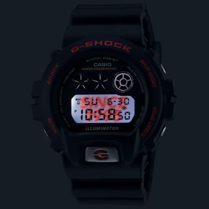Die DW-6900TR-1 im Dunkeln mit eingeschalteter LED-Beleuchtung und Schriftzug "Since 1995" im Hintergrund.