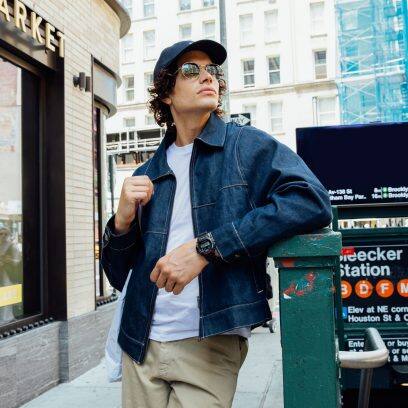 Die G-SHOCK Armbanduhr DW-6900U-1 am Handgelenk einer Person in Außenumgebung.