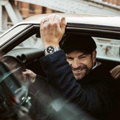 Die Chronographenuhr EFR-575D-1AEF mit Metallband am Handgelenk eines Mannes beim Aussteigen aus einem Oldtimer.