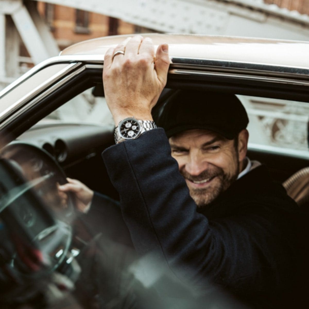 Die Chronographenuhr EFR-575D-1AEF mit Metallband am Handgelenk eines Mannes beim Aussteigen aus einem Oldtimer.
