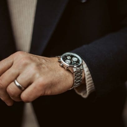 Nahaufnahme der schwarzen EDIFICE-Uhr EFR-575D-1AEF am Handgelenk eines Mannes in einem blauen Anzug.