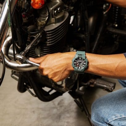 G-SHOCK GA-010-2A Armbanduhr am Handgelenk eines Mannes, der an einem Motorrad schraubt
