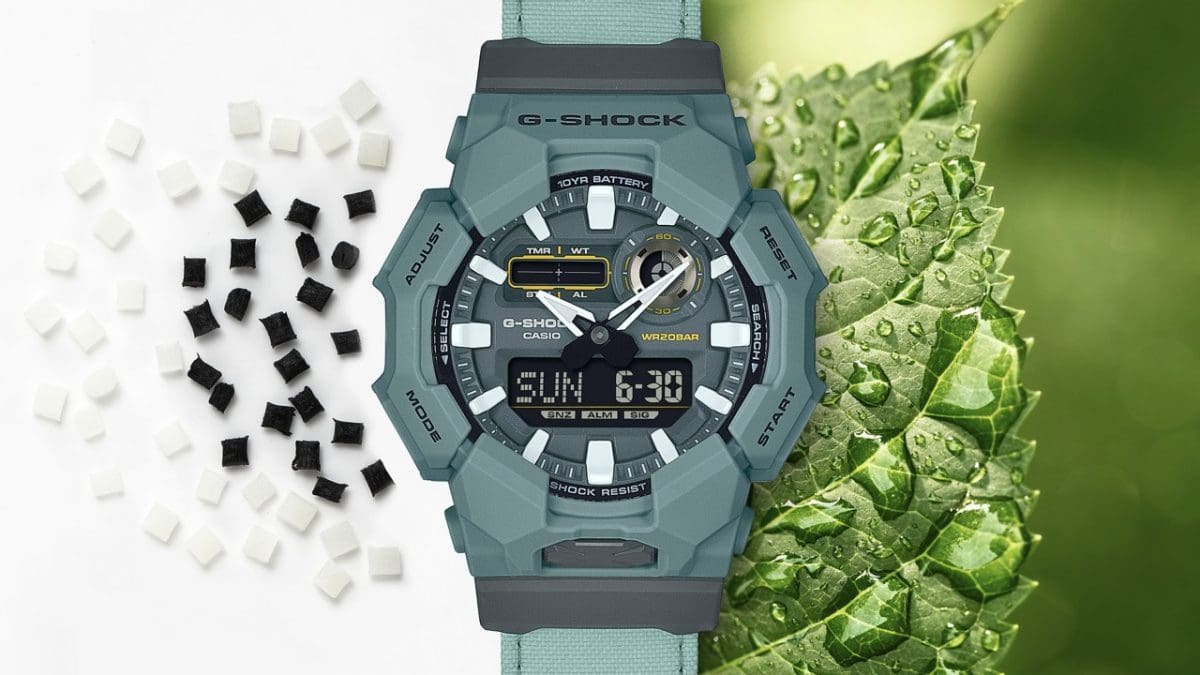 Neben der GA-010CE-2AER ist ein grünes Blatt mit Wassertropfen zu sehen und auf der anderen Seite schwarze und weiße Kügelchen der Gehäusematerials Resin