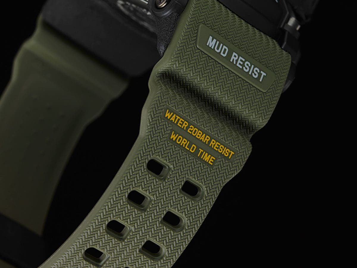Auf dem Olivgrünen und strukturierten Armband sind die drei Vorteile MUD RESIST, WATER 20BAR RESIST und WORLD TIME aufgebracht