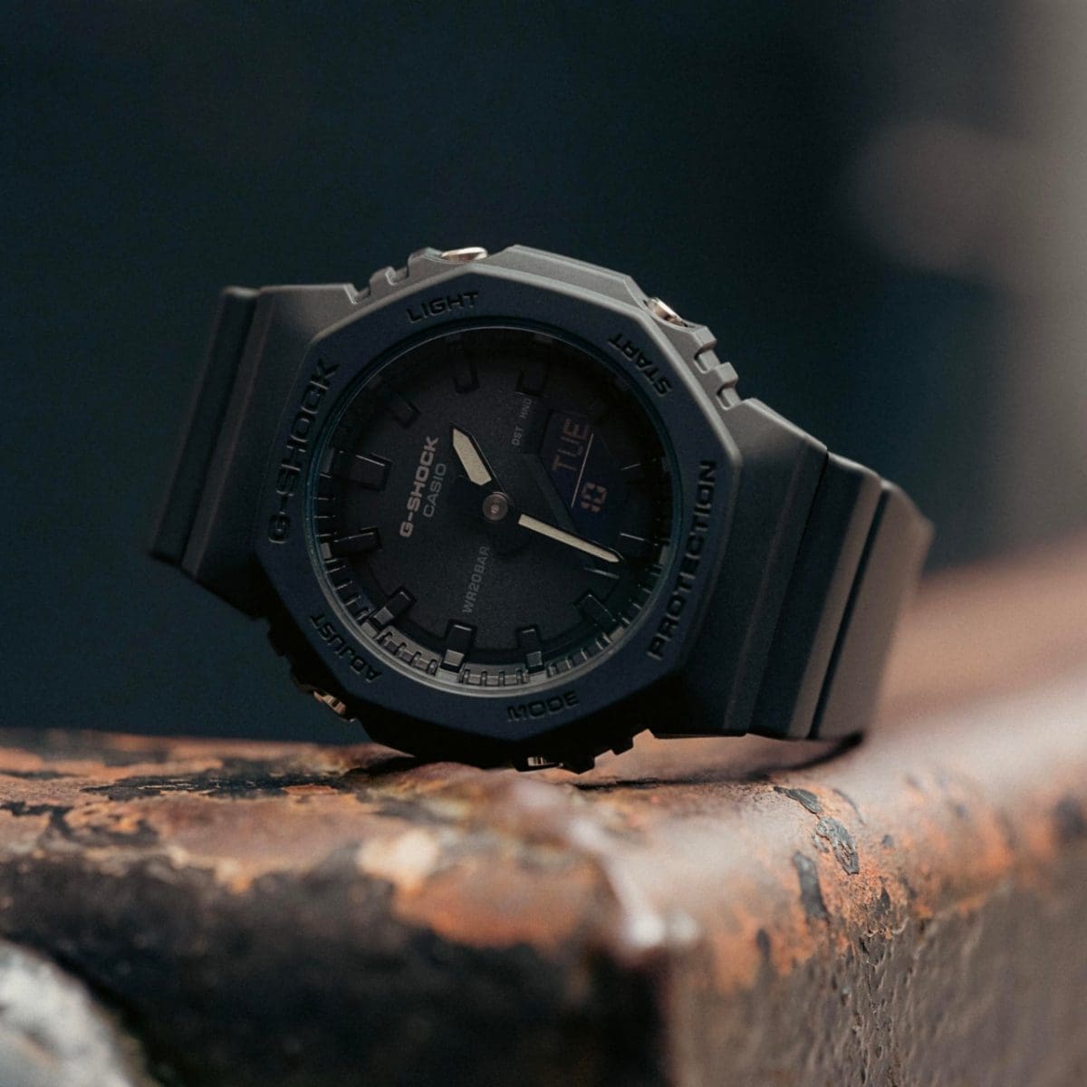 Die komplett schwarze GMA-92100BB-1A Armband Uhr von G-SHOCK liegt auf einem Stahlträger