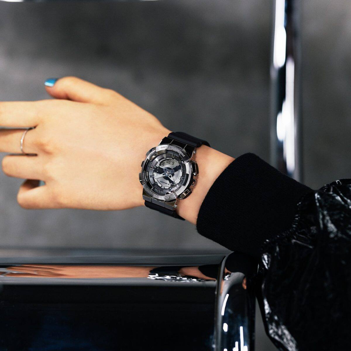 Nahaufnahme der Digital-Analoguhr von G-SHOCK mit kantigem silbernem Metallgehäuse am Handgelenk einer Frau
