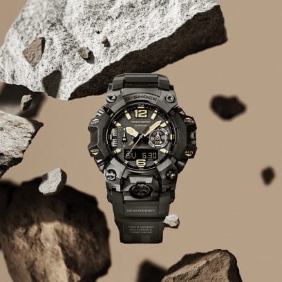 Die MUDMASTER Armbanduhr GWG-B1000-1A3 wird von Gesteinsbrocken umschwebt