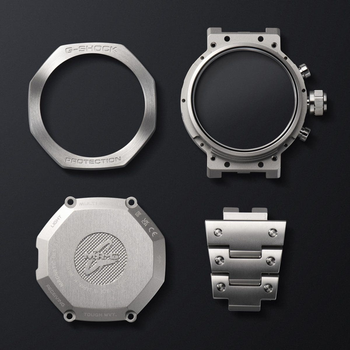 Lünette, Gehäuse, Rückseite und Gliederarmband der MRG-B2100D-2ADR nebeneinander auf schwarzem Untergrund