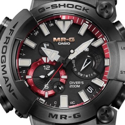 Nahaufnahme des analogen Zifferblatts der G-SHOCK Armbanduhr MRG-BF1000B-1A in Schwarz mit weißen Zeigern und Indices, einem goldfarbenen MR-G-Logo, einem rotumrandeten Hilfszifferblatt und einem roten Rahmen mit Minuten-Skalierung rund um das Zifferblatt.