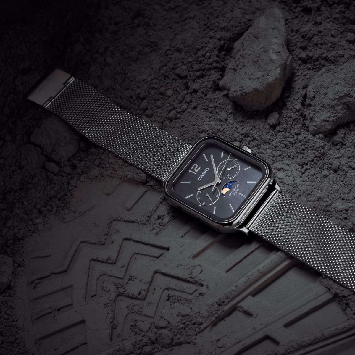 Die CASIO TIMELESS COLLECTION Armbanduhr MTP-M305M-1AV dekorativ drapiert neben einem Schuhabdruck in staubigem Boden.