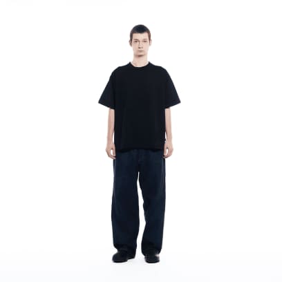 Ein Mann mit dunkler Jeans trägt das GXFAB T-Shirt