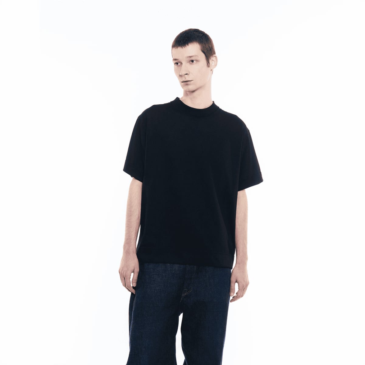 Ein Mann mit dunkler Jeans trägt das GXFAB T-Shirt