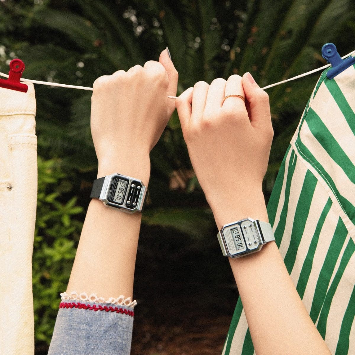 Zwei Frauenhände greifen von unten an eine Wäscheleine, an den Handgelenken tragen sie die zwei hellen Varianten der A-100 Serie