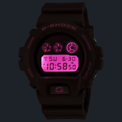 Die DW-6900HH-5ER im Dunkeln mit eingeschalteter LED-Beleuchtung, welche Pink leuchtet und die Digitalanzeige erhellt