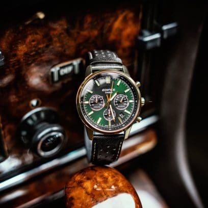 Der EDIFICE-Chronograph mit grüner Lünette und schwarzem Lederarmband liegt auf dem Schaltknüppel in einem Auto.