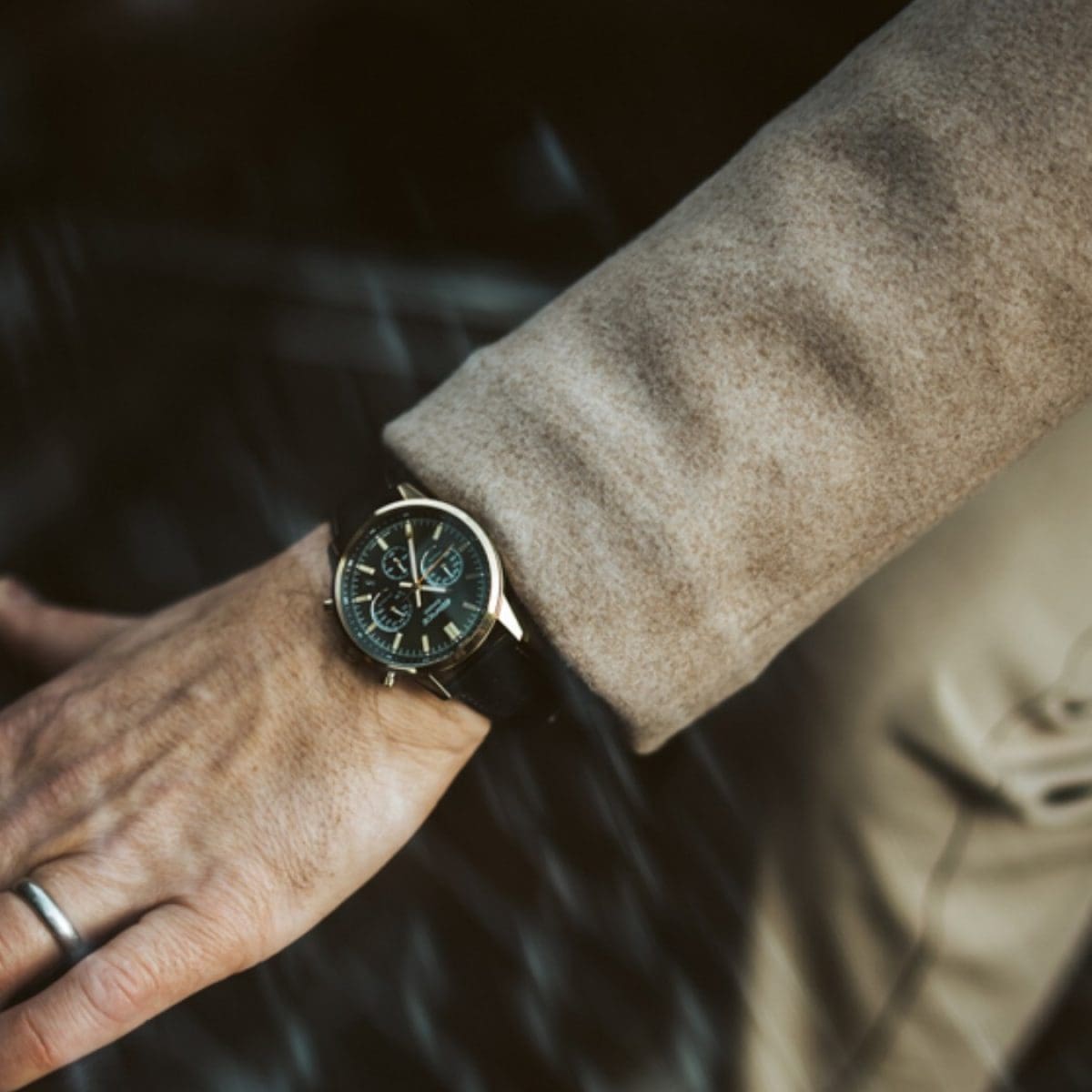 Die Chronographenuhr EFR-575CL-3AEF mit schwarzem Lederarmband am Handgelenk eines Mannes, der sich an einer Autotür festhält.