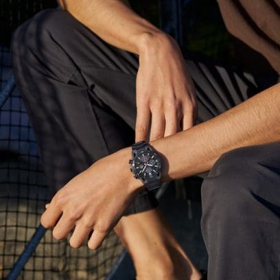Halbtotale von einem Mann inder Hocke, der die schwarze Armbanduhr EFS-S640DC-1AV von EDIFICE trägt.