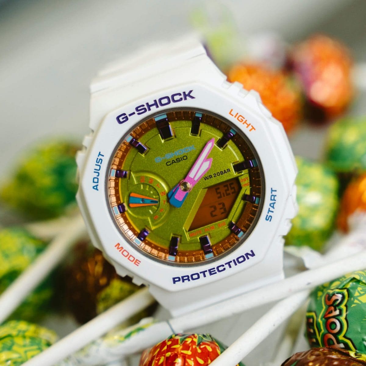 G-SHOCK "GMA-S2100BS-7A" mit weißem Armband liegt auf bunten Lollipops