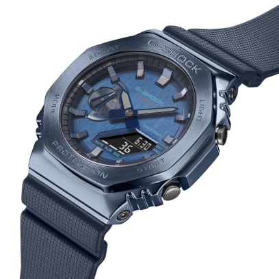 Die seitliche Nahaufnahme der G-SHOCK Armbanduhr GM-2100N-2A zeigt die silberfarbenen Bedientasten außen am blauen Gehäuse.
