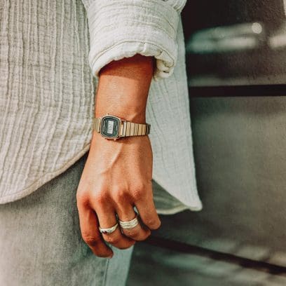 Eine Person trägt am Handgelenk die CASIO Vintage Uhr LA670WEGA mit goldfarbenem Armband und digitaler Anzeige