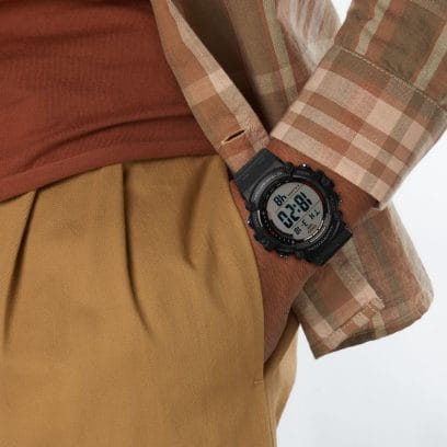 El AE-1500WH-1AV en la muñeca de un hombre que viste una camisa a cuadros, una camiseta de color rojo óxido y pantalones de color amarillo mostaza.