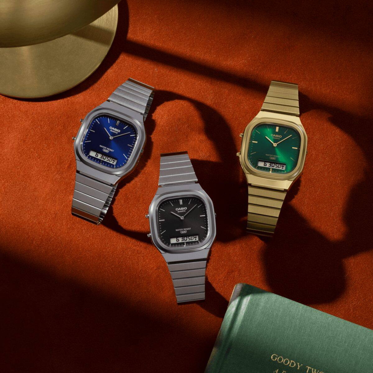 Los dos AQ-240E plateados con esferas negras y azul oscuro pueden verse junto al modelo dorado con una esfera verde de la misma serie