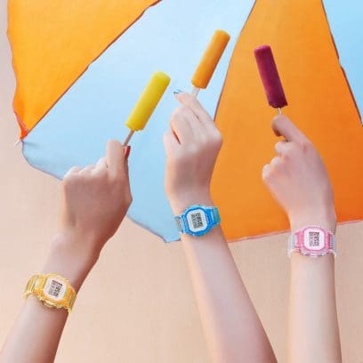 Tres mujeres sostienen coloridos hielos de agua, en sus muñecas llevan diferentes modelos del reloj de pulsera BGD-565SJ de G-SHOCK en amarillo, azul claro y rosa
