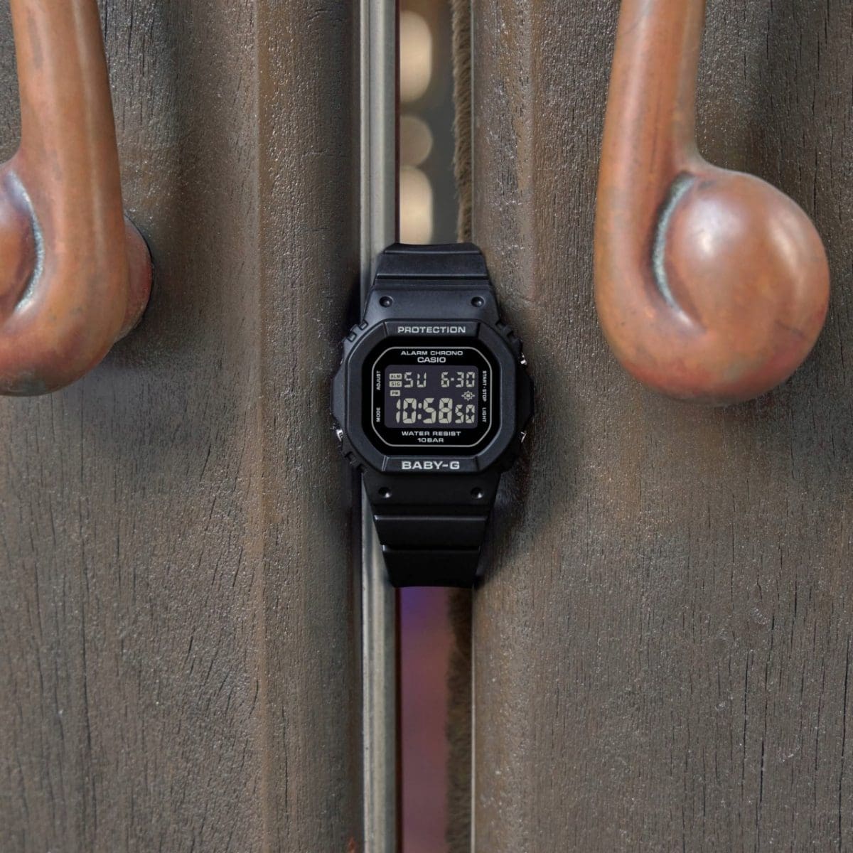 El modelo BGD-565U-1ER entre dos asas metálicas curvadas, frente a una superficie industrial rugosa. 