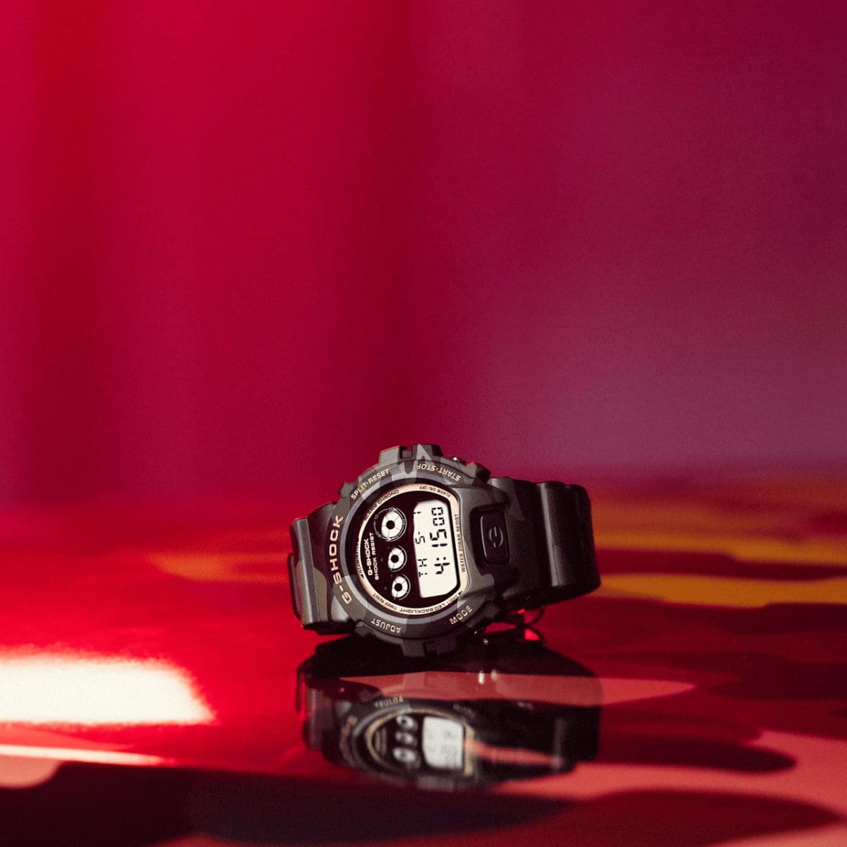 El reloj de pulsera DW-6900CMG-3ER de G-SHOCK, con detalles dorados en la caja y alrededor de la esfera