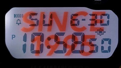 Primer plano de la pantalla DW-6900TR-4 en la oscuridad con la iluminación LED encendida y las palabras "Desde 1995" de fondo.