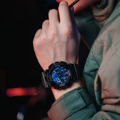 Primer plano del reloj de pulsera G-SHOCK GA-100RGB-1A en la muñeca de un hombre
