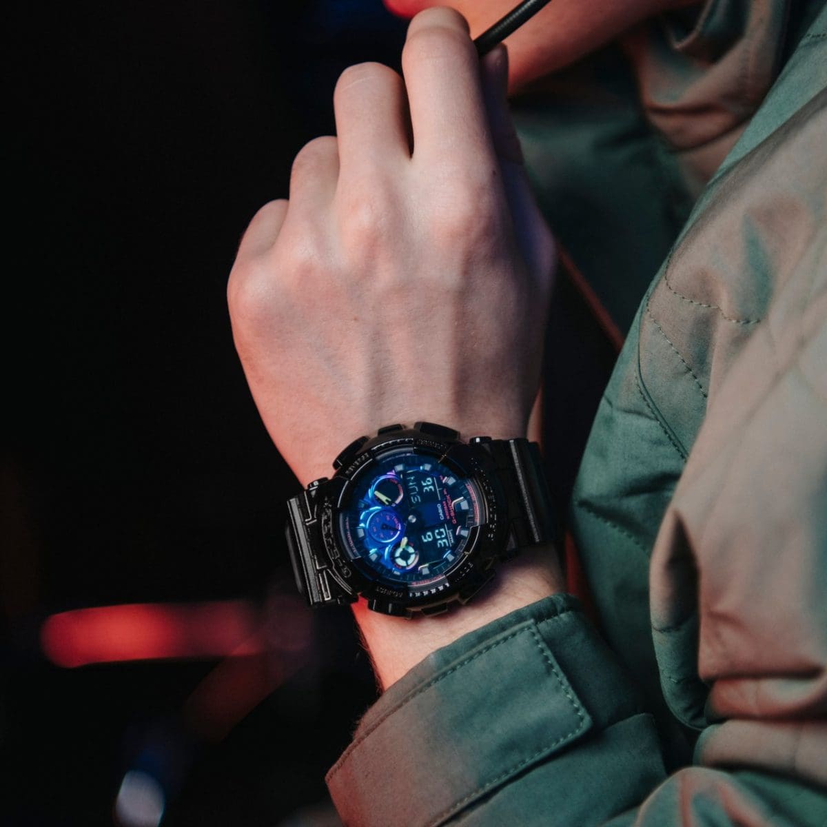 Primer plano del reloj de pulsera G-SHOCK GA-100RGB-1A en la muñeca de un hombre