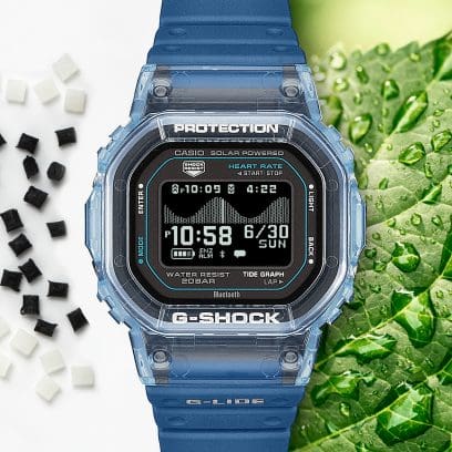 El reloj de pulsera G-SHOCK está rodeado, por un lado, de bolitas negras y blancas de resina y, por el otro, de una hoja verde con gotas de agua