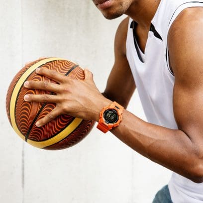 Reloj de pulsera G-SHOCK GD-010-4 en la muñeca de un hombre jugando al baloncesto