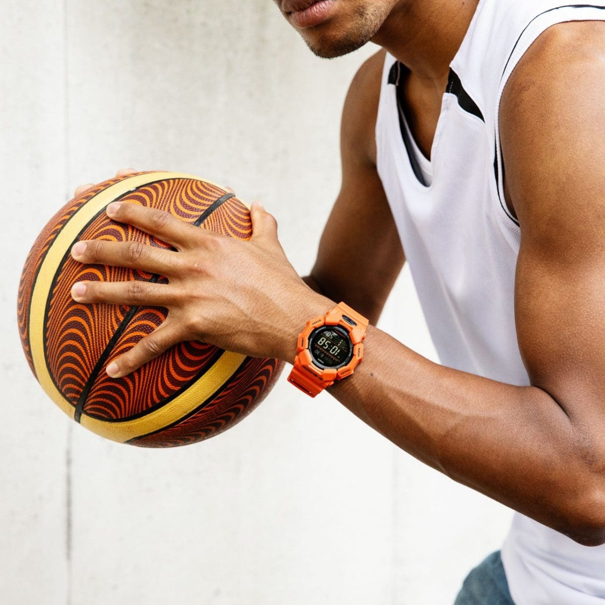 Reloj de pulsera G-SHOCK GD-010-4 en la muñeca de un hombre jugando al baloncesto