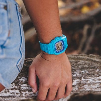 El GLX-S5610-2 en la muñeca de una persona apoyada en el tronco de un árbol