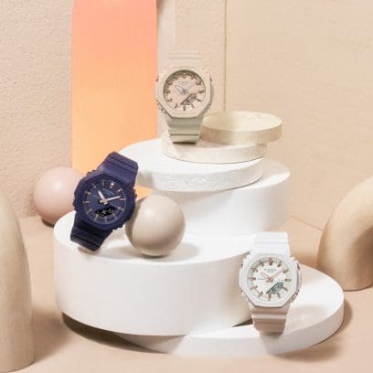Tres variantes de color azul, beige y blanco del GMA-P2100M colocado sobre una torre formada por discos redondos